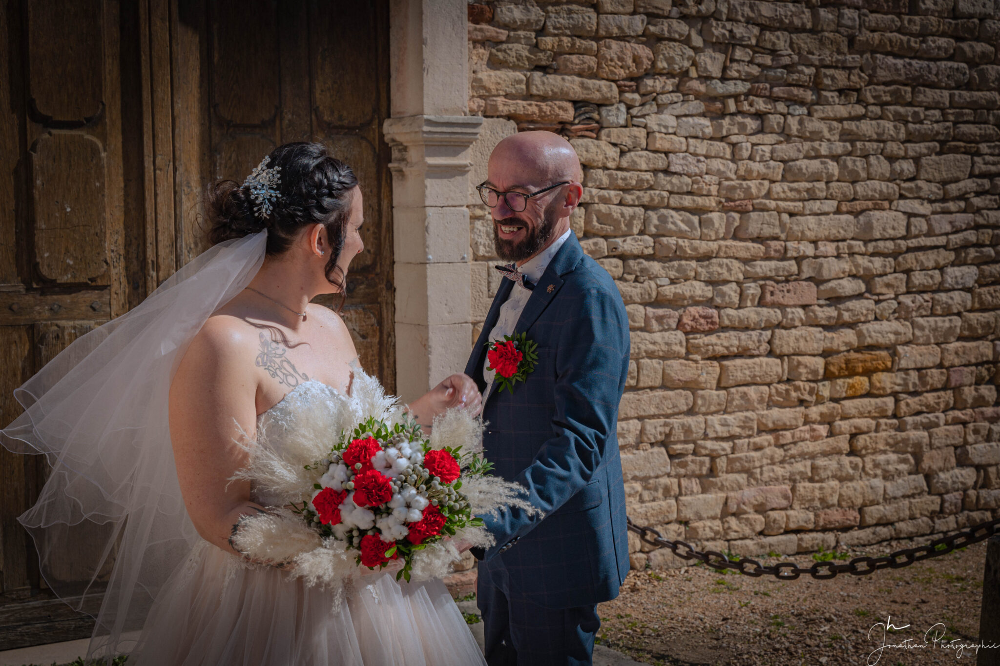 Photo des deux mariés avec le bouquet de fleurs dans la main de la mariée