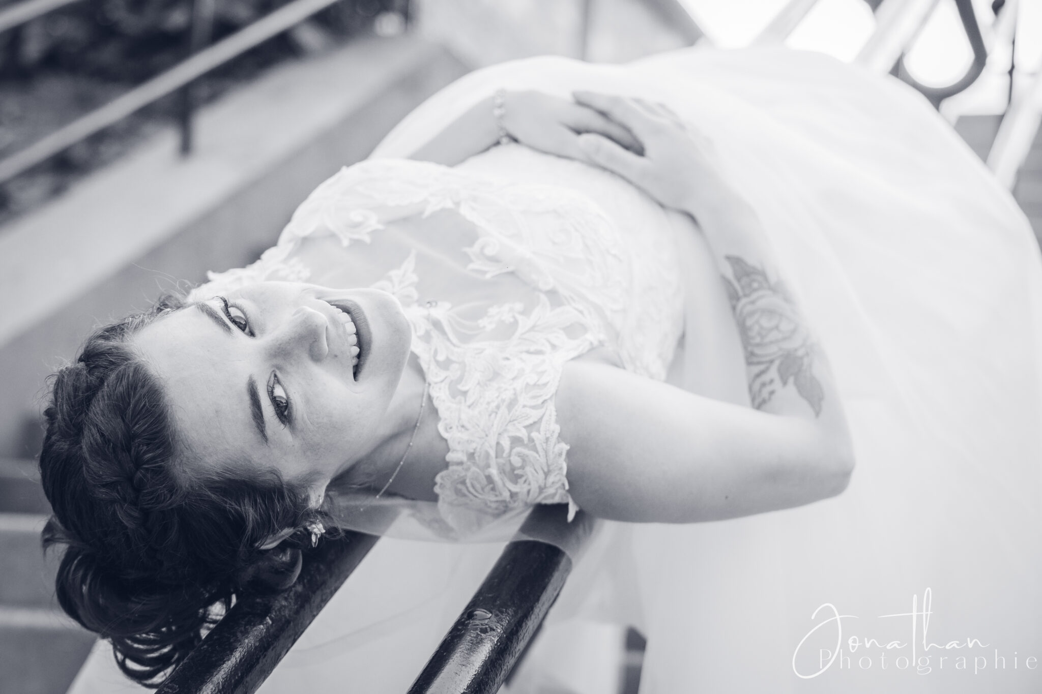 Photo de la mariée allongée sur le rebord d'un escalier montrant son bonheur